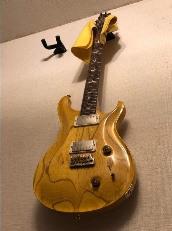 木目を生かしたナチュラルフィニッシュのPRS Custom 24を壁掛けした様子