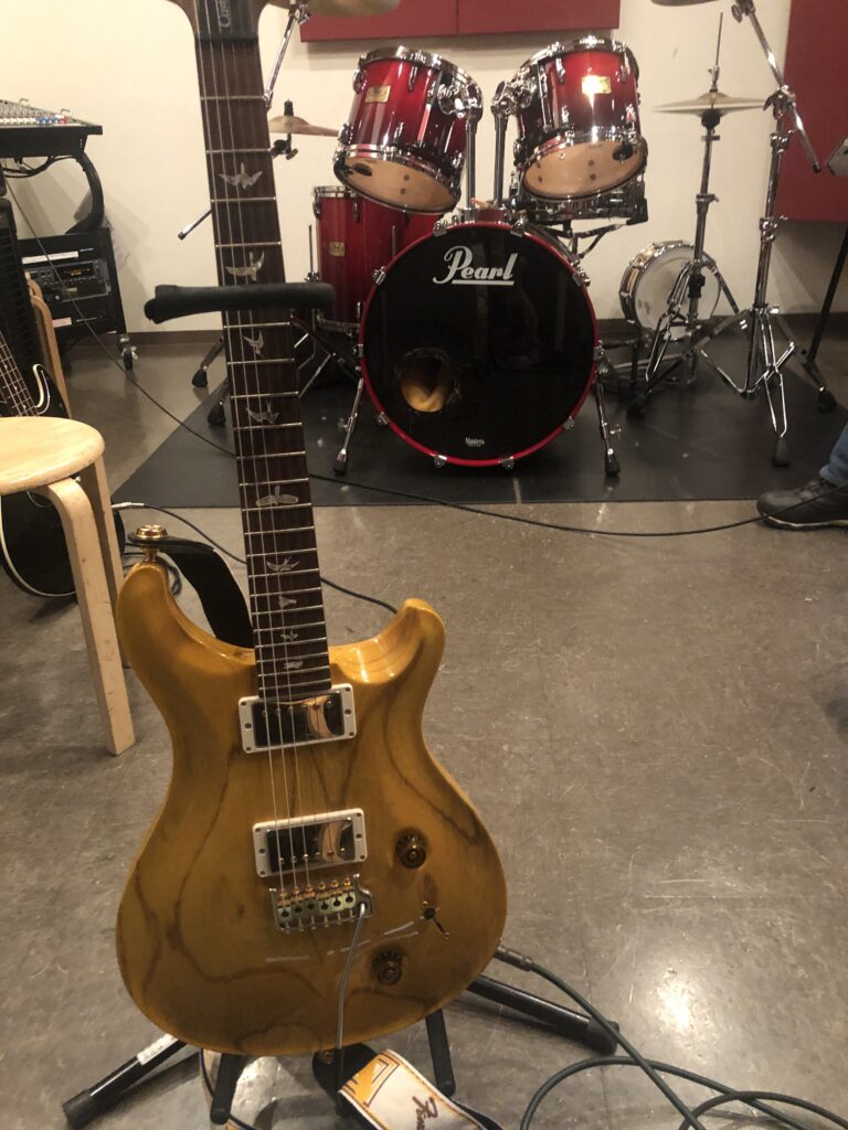 リハーサルスタジオでギタースタンドに置いた筆者所有のナチュラル仕上げPRS Custom 22
